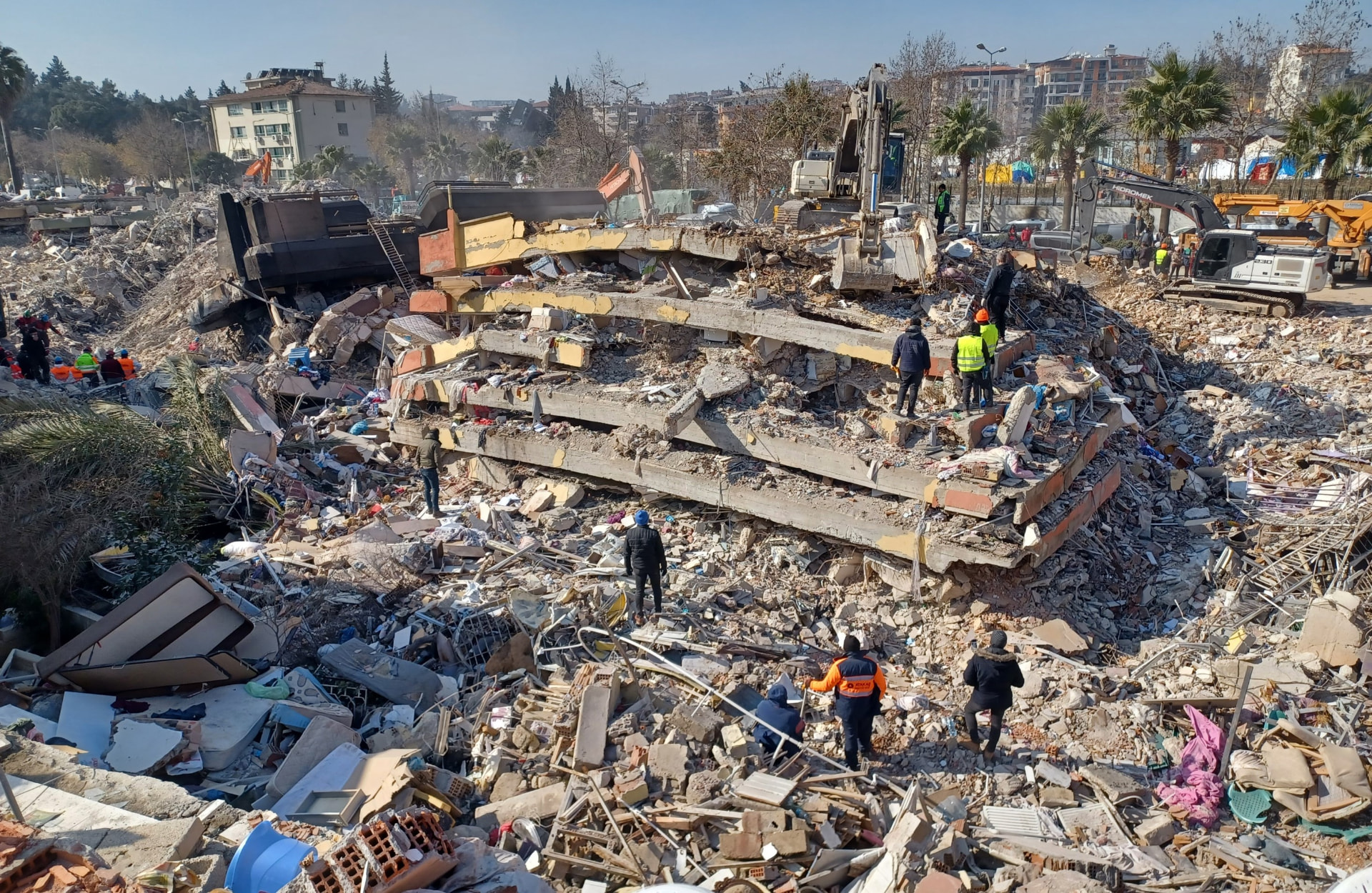 Search teams working across a collapsed building site